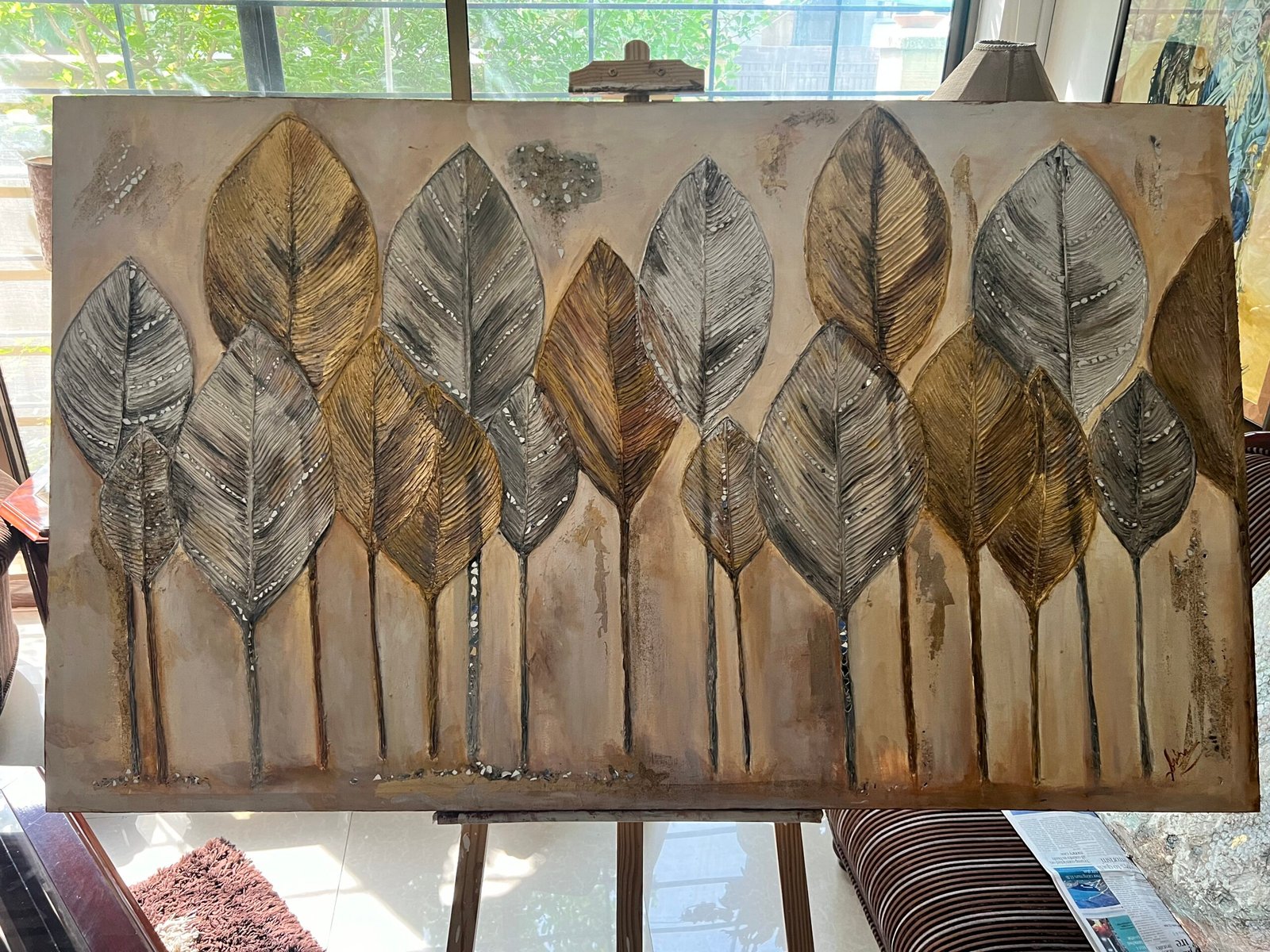 a painting of leaves on a easel